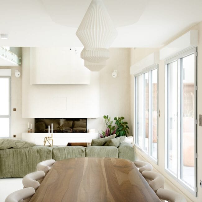 Salle à manger de prestige à Bordeaux avec table sur-mesure en bois massif, chaises bouclées et suspensions plissées